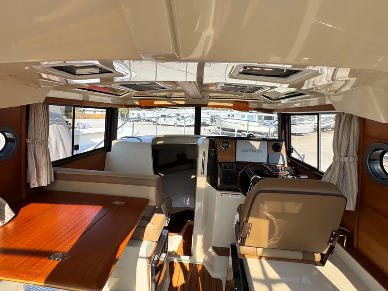 Slide: The Image of Interior of 2022 Ranger Tugs R-25 boat with helm, seating, and wood accents. - 7