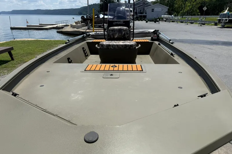 Slide: The Image of 2022 Tracker Grizzly 1860 CC boat docked by a scenic lake. - 17