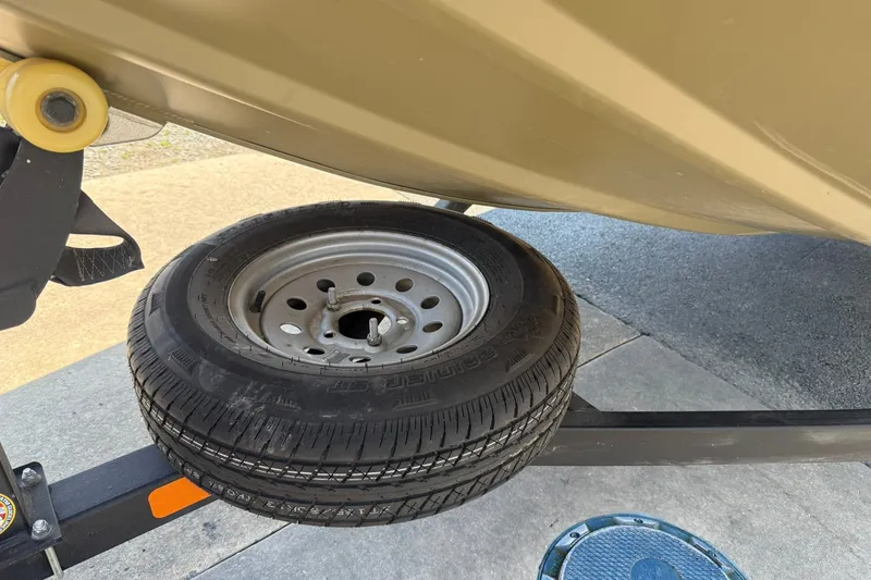 Slide: The Image of 2022 Tracker Grizzly 1860 CC trailer with spare tire mounted underneath. - 16