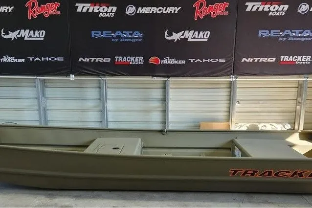 The Image of 2027 Tracker Grizzly 15 Jon boat displayed indoors with branded banners in the background. - 1