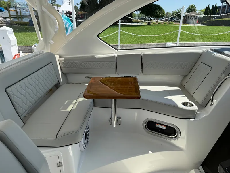 Slide: The Image of The interior of the Pursuit OS 355 Offshore features an elegant seating area with a wooden table. - 23