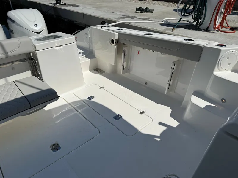 Slide: The Image of The image shows the cockpit of a Pursuit OS 355 Offshore boat. It features cushioned seating and storage. - 13