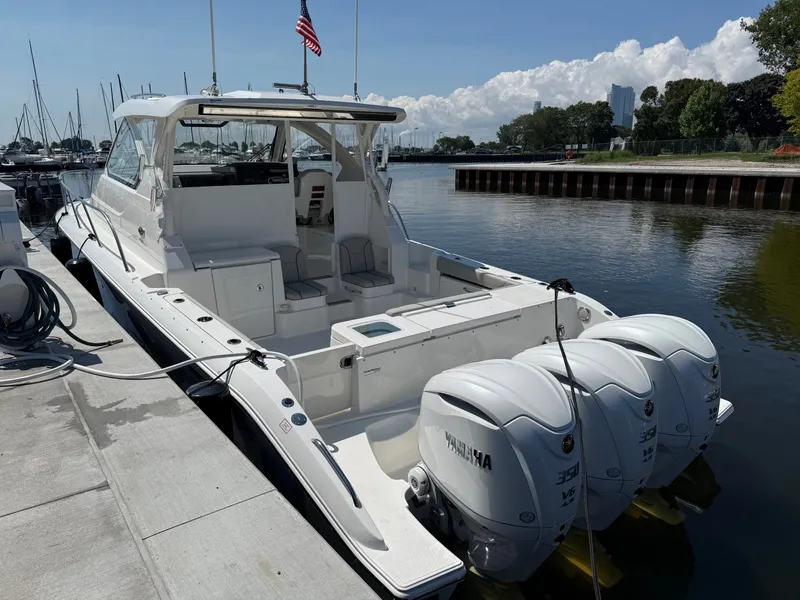 Slide: The Image of The 2027 Pursuit OS 355 Offshore is docked. It features three outboard engines and a spacious cabin. - 5