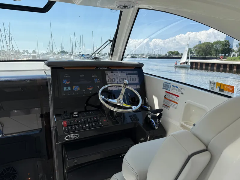 Slide: The Image of The cockpit of a 2027 Pursuit OS 355 Offshore with a modern helm and harbor view. - 19