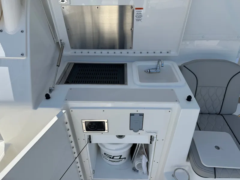 Slide: The Image of The 2027 Pursuit OS 355 Offshore features a compact outdoor kitchen with a sink and seating area. - 14