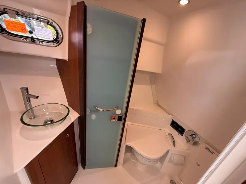 Slide: The Image of The image shows a modern boat bathroom with a glass sink, toilet, and shower area. - 35