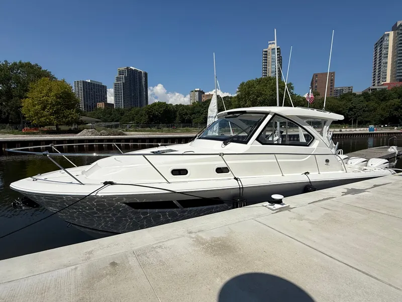Slide: The Image of A white Pursuit OS 355 Offshore boat docked in an urban setting. - 2