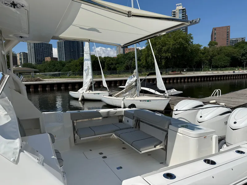 Slide: The Image of A 2027 Pursuit OS 355 Offshore docked. Sailboats and buildings are visible in the background. - 11