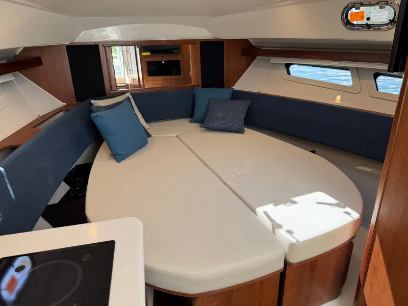 Slide: The Image of Interior of a modern yacht with a sleek seating area and blue cushions, surrounded by windows. - 29