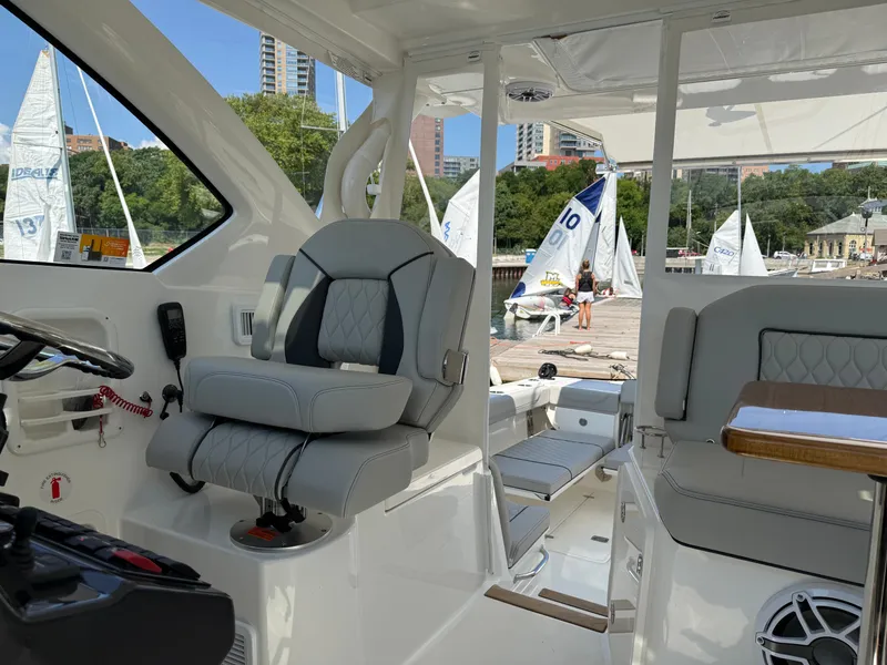 Slide: The Image of The image shows the cockpit of a Pursuit OS 355 Offshore with gray seats and a wooden table. - 25