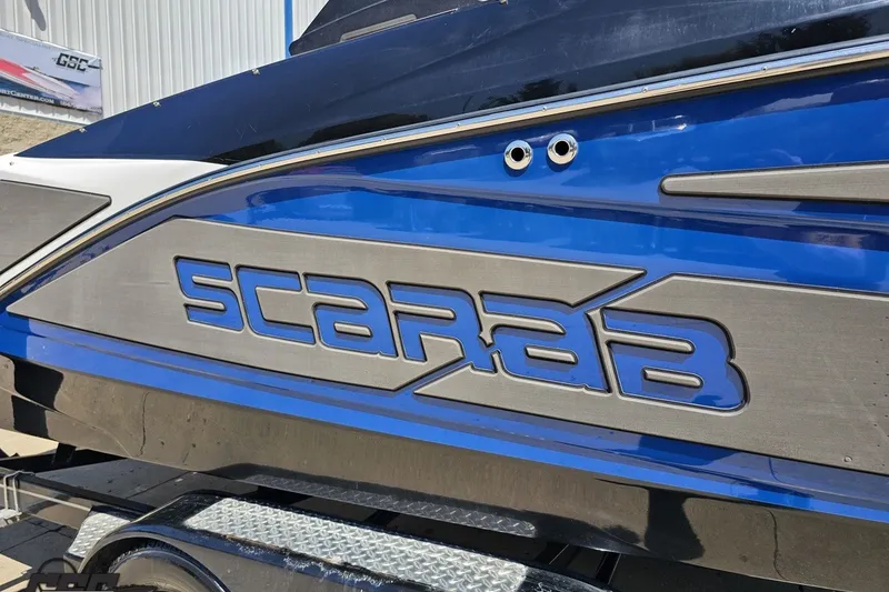 Slide: The Image of 2022 Scarab 255 Wake ID boat with bold blue and silver branding. - 7