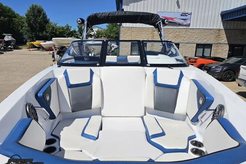 Slide: The Image of 2022 Scarab 255 Wake ID boat interior with blue and white seating, parked outdoors. - 18
