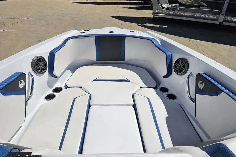 Slide: The Image of 2022 Scarab 255 Wake ID boat interior with blue and white seating, cup holders, and speakers. - 84