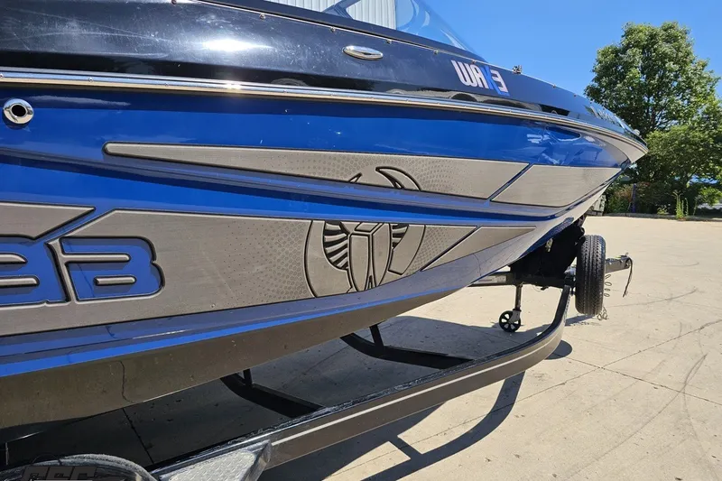 Slide: The Image of 2022 Scarab 255 Wake ID boat with blue and silver detailing on a trailer. - 8