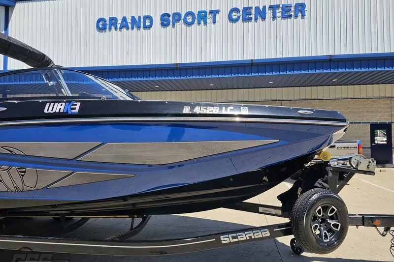 Slide: The Image of 2022 Scarab 255 Wake ID boat at Grand Sport Center, blue and black design. - 13