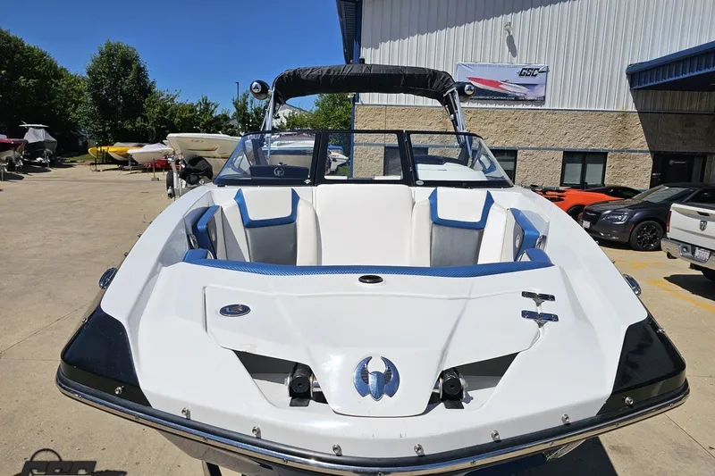 Slide: The Image of 2022 Scarab 255 Wake ID boat in a sunny outdoor showroom setting. - 17