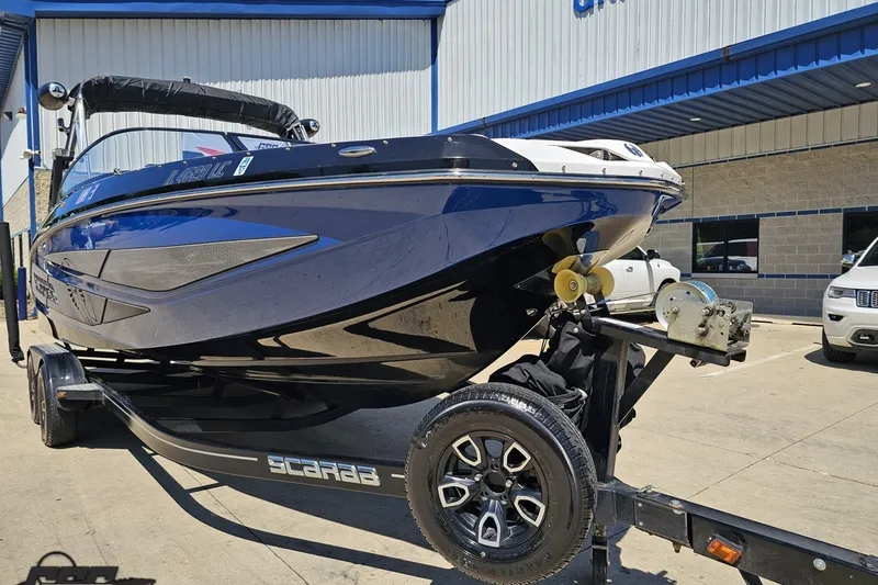 Slide: The Image of 2022 Scarab 255 Wake ID boat on trailer outside a dealership. - 15