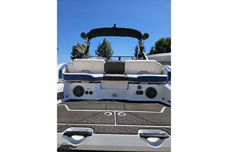 Slide: The Image of 2022 Scarab 255 Wake ID boat interior with seating and speakers, under clear blue sky. - 33