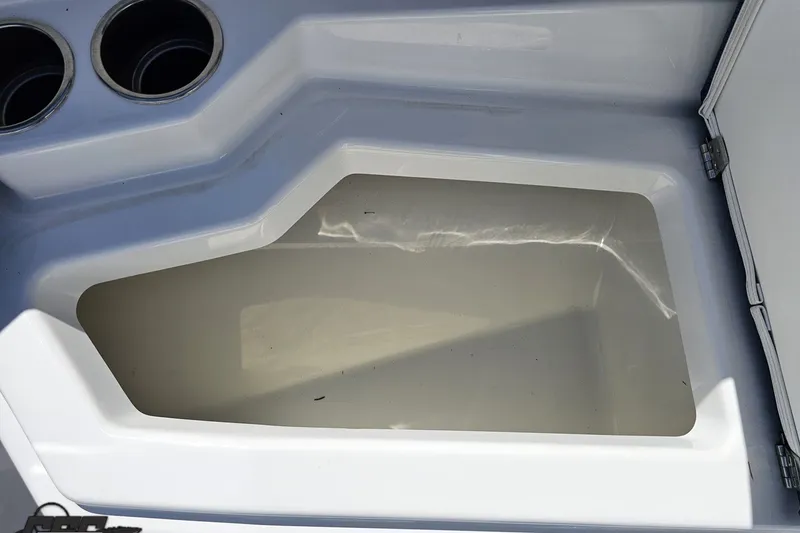 Slide: The Image of Storage compartment in 2022 Scarab 255 Wake ID boat, featuring cup holders and sleek design. - 99