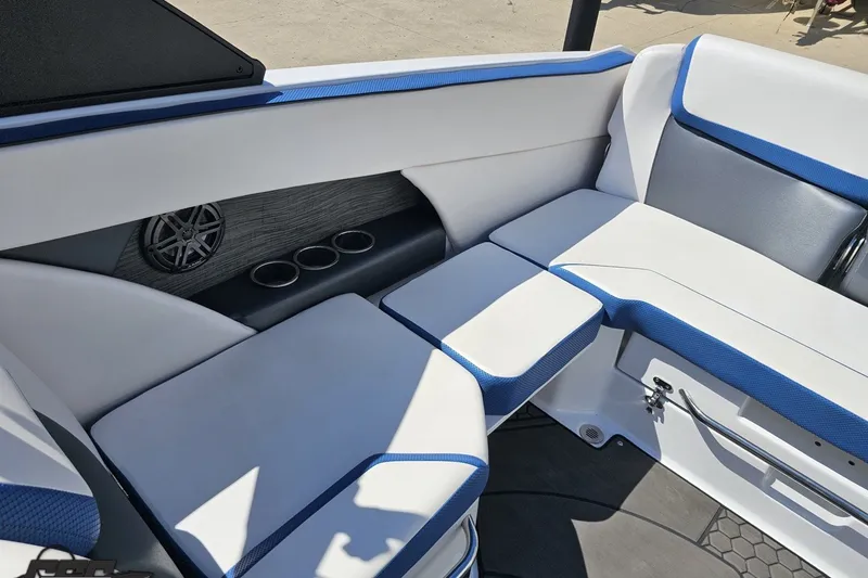 Slide: The Image of 2022 Scarab 255 Wake ID boat interior with white and blue seating, cup holders, and speaker. - 108