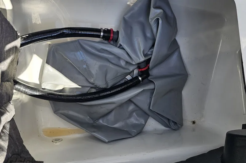 Slide: The Image of 2022 Scarab 255 Wake ID boat compartment with hoses and folded material. - 55