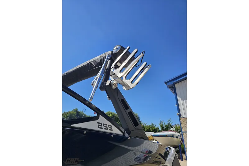 Slide: The Image of 2022 Scarab 255 Wake ID boat with wakeboard rack against clear blue sky. - 23