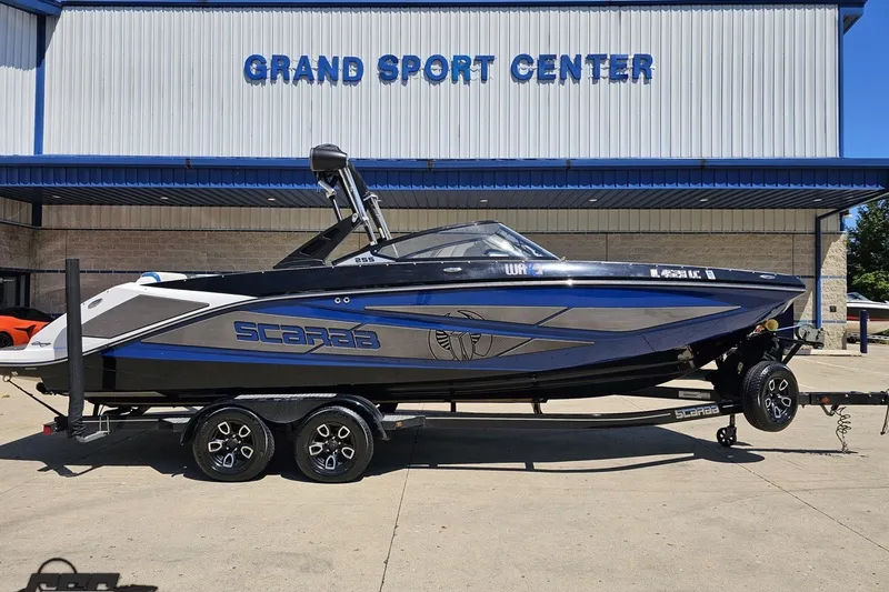 Slide: The Image of 2022 Scarab 255 Wake ID boat at Grand Sport Center, displayed on a trailer. - 2