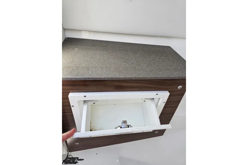 Slide: The Image of Storage compartment in 2022 Scarab 255 Wake ID boat, featuring a sleek wooden finish. - 68