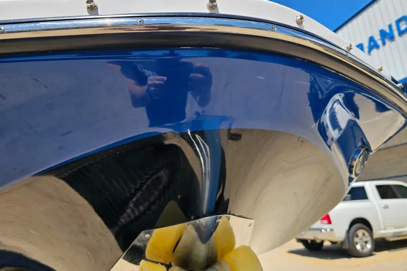 Slide: The Image of 2022 Scarab 255 Wake ID boat hull with blue and white finish, parked outdoors. - 124
