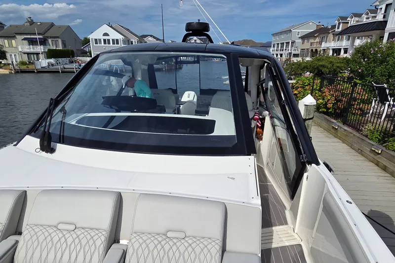 Slide: The Image of 2023 Sea Ray Sundancer 370 Outboard docked near waterfront homes. - 17
