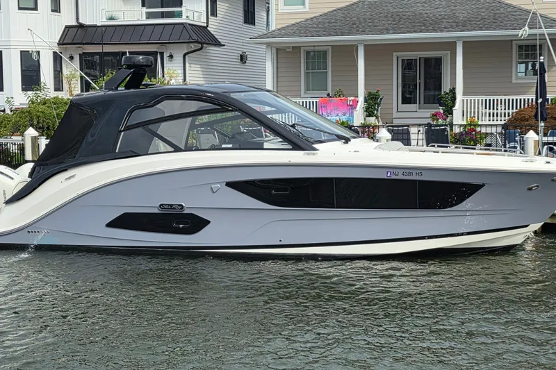 The Image of 2023 Sea Ray Sundancer 370 Outboard docked near waterfront homes. - 0
