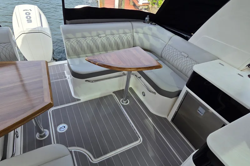 Slide: The Image of Luxurious seating area on 2023 Sea Ray Sundancer 370 Outboard yacht with elegant wood tables. - 12