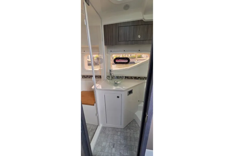 Slide: The Image of Interior of 2023 Sea Ray Sundancer 370 Outboard, featuring modern bathroom design with sink and window. - 24