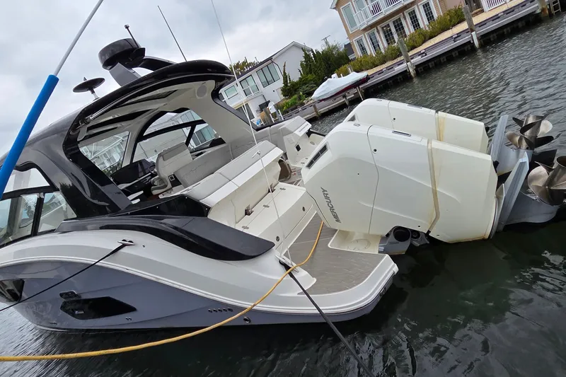 Slide: The Image of 2023 Sea Ray Sundancer 370 Outboard docked, showcasing sleek design and powerful engines. - 5