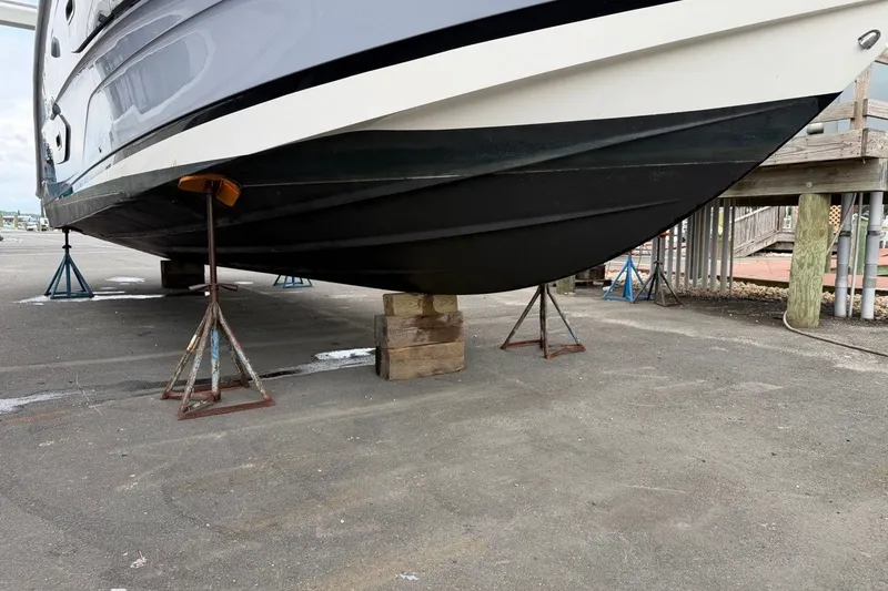 Slide: The Image of 2023 Sea Ray Sundancer 370 Outboard on stands, showcasing its sleek hull design. - 8