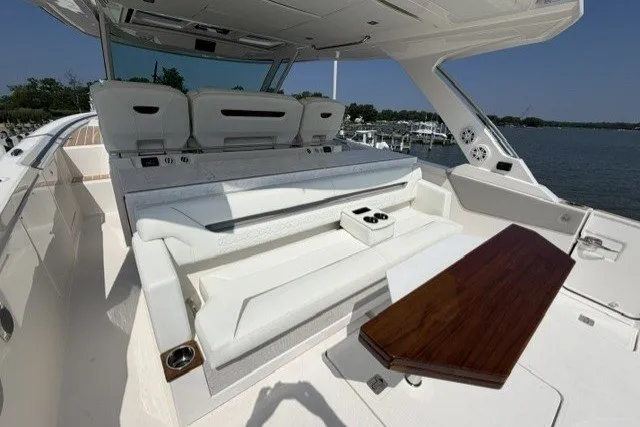 Slide: The Image of Luxurious seating area on 2025 Tiara Yachts 43 LS, featuring elegant white upholstery and wooden table. - 23