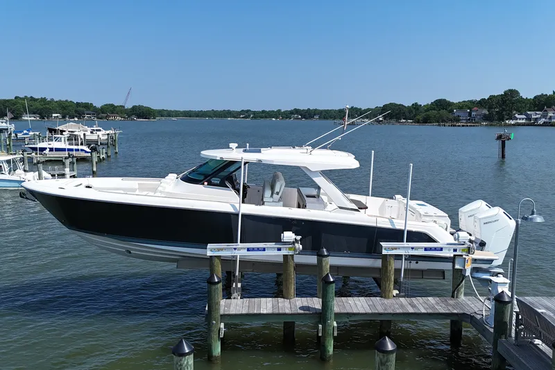 Slide: The Image of 2025 Tiara Yachts 43 LS docked on a serene waterfront, showcasing sleek design and luxury. - 4
