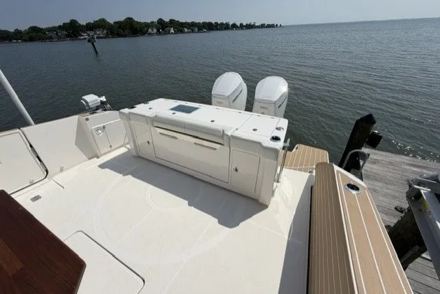 Slide: The Image of 2025 Tiara Yachts 43 LS boat deck with dual engines, docked by a serene waterfront. - 24