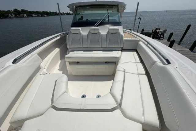 Slide: The Image of 2025 Tiara Yachts 43 LS boat with spacious seating, docked by a serene waterfront. - 9