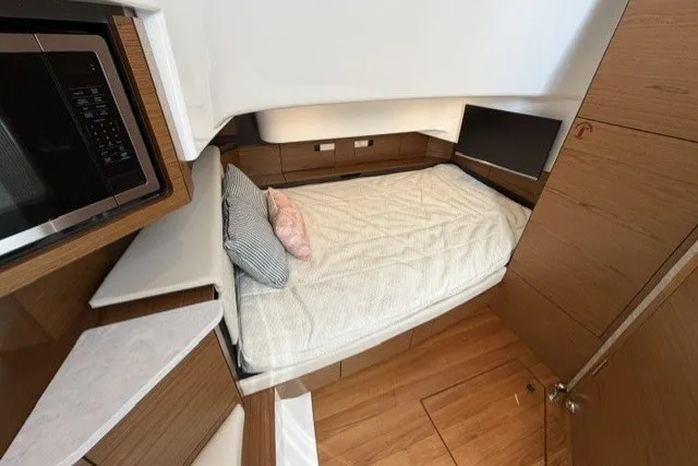 Slide: The Image of 2025 Tiara Yachts 43 LS cabin interior with bed, wood finish, and modern amenities. - 26