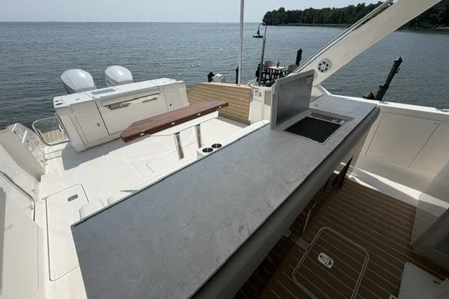 Slide: The Image of 2025 Tiara Yachts 43 LS deck with outdoor kitchen and scenic water view. - 18