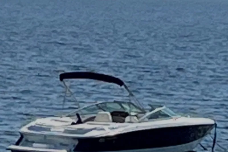 The Image of 2006 Cobalt 220 boat on calm blue water with a canopy. - 0