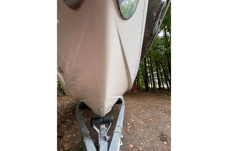Slide: The Image of 2006 Cobalt 220 boat on trailer, parked in wooded area. - 11