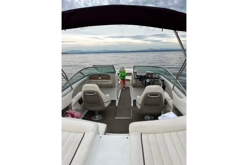 Slide: The Image of 2006 Cobalt 220 boat interior with lake view and child in life jacket. - 2