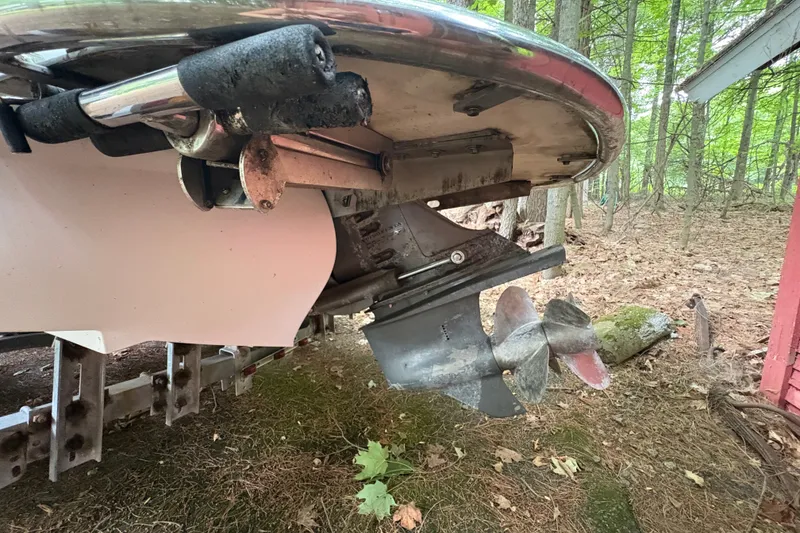 Slide: The Image of 2006 Cobalt 220 boat propeller and stern, parked in a wooded area. - 6