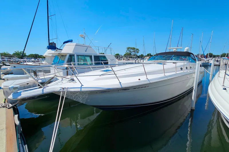 The Image of 1995 Sea Ray 500 Sundancer yacht docked at marina under clear blue sky. - 0