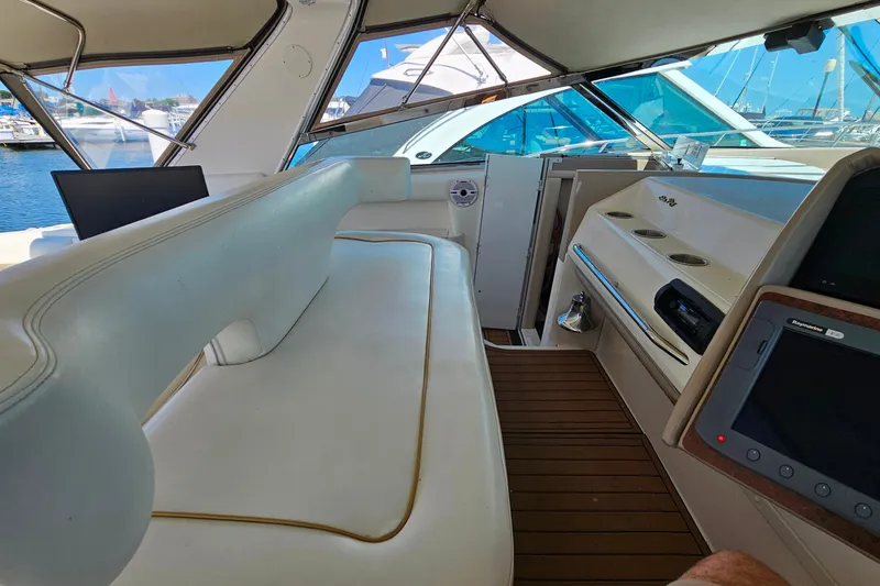Slide: The Image of Interior view of a 1995 Sea Ray 500 Sundancer yacht with white seating and wooden flooring. - 17