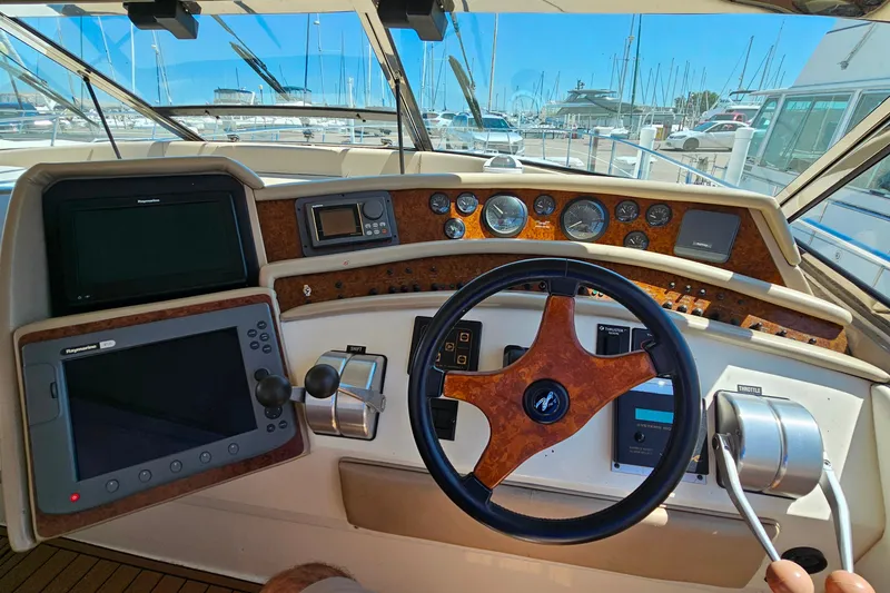 Slide: The Image of Cockpit of a 1995 Sea Ray 500 Sundancer yacht with navigation instruments and steering wheel. - 16