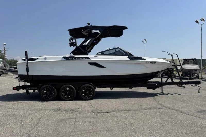 Slide: The Image of 2025 Centurion Ri245 boat on trailer, sleek design, parked outdoors. - 12