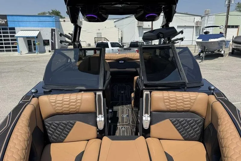 Slide: The Image of 2025 Centurion Ri245 boat interior with tan and black seating, docked outdoors. - 5